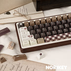 Close-up angle of beige modifier keys and coffee brown alphas on mechanical keyboard